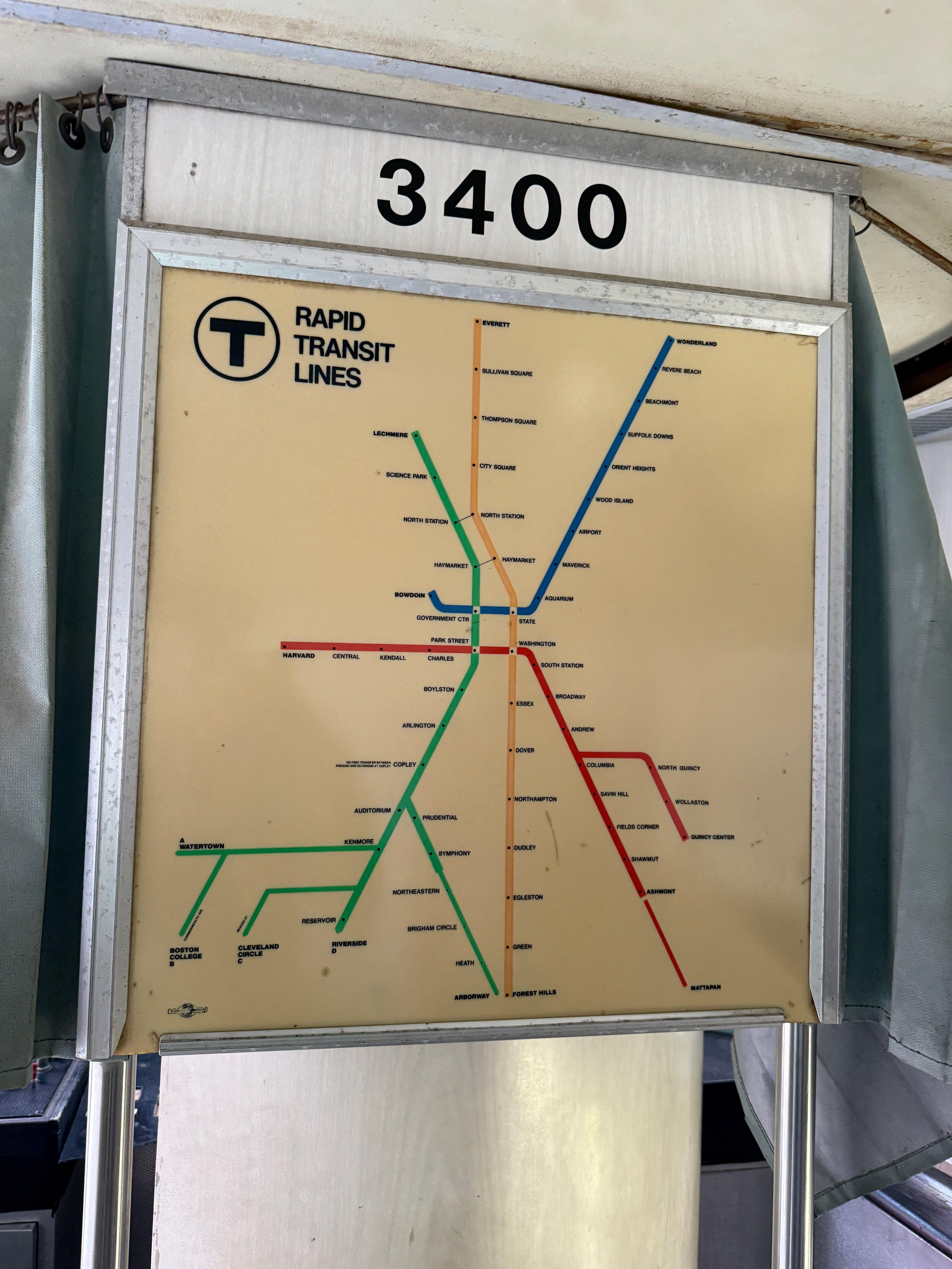 A close-up of a vintage MBTA “Rapid Transit Lines” map inside a vehicle, showing the old configuration of the Red, Orange, Blue, and Green lines. Above the map is the number “3400”.